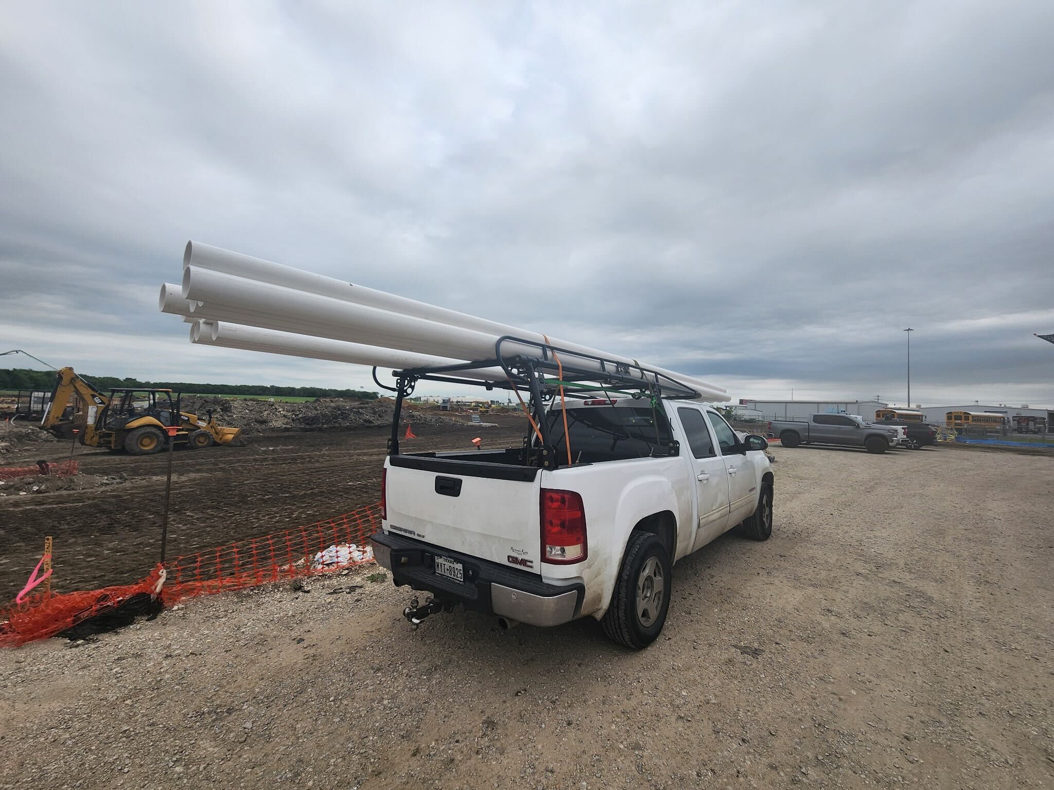 BlackIron Hauling truck loaded with PVC pipes at a construction job site in DFW