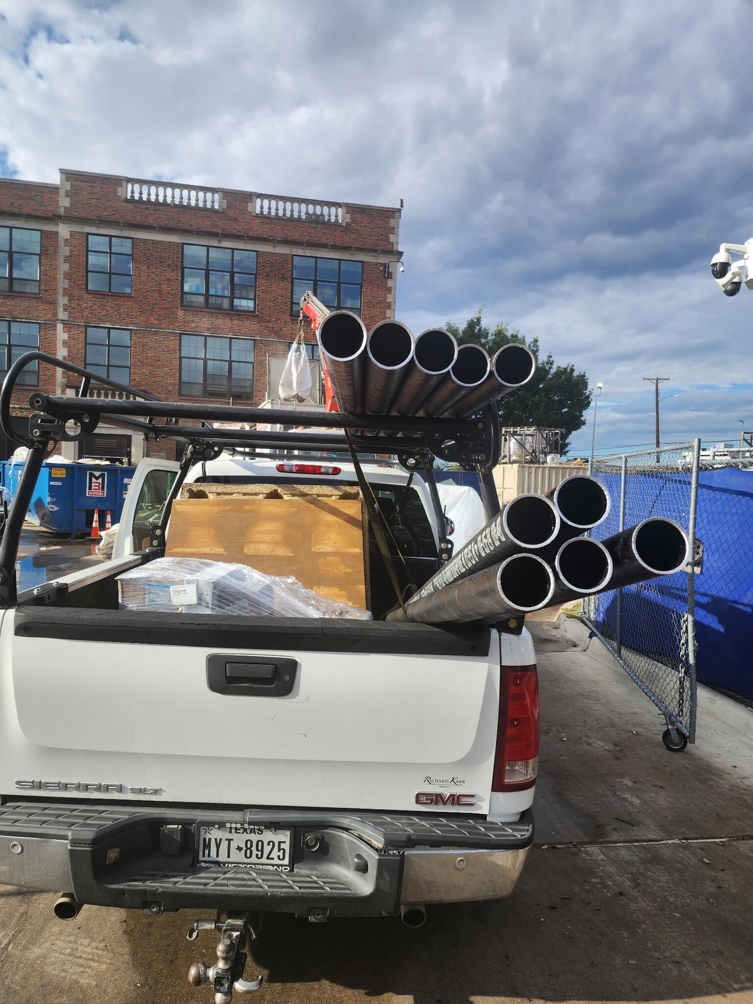 BlackIron Hauling GMC truck loaded with steel pipes for delivery in Dallas-Fort Worth