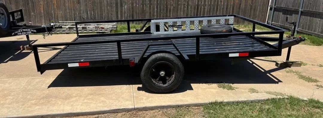 BlackIron Hauling 12-foot utility trailer side view with drop-down gate and spare tire